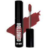 LIP MUD IN BLACK PACKAGING WITH A WINDOW TO SEE COLOR AND NEXT TO THE PRODUCT'S WAND. COLOR SWATCH BEHIND PRODUCT OF A DARKER RED-PINK COLOR