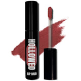 LIP MUD IN BLACK PACKAGING WITH A WINDOW TO SEE COLOR AND NEXT TO THE PRODUCT'S WAND. COLOR SWATCH BEHIND PRODUCT OF A MID-TONED RED-PINK COLOR